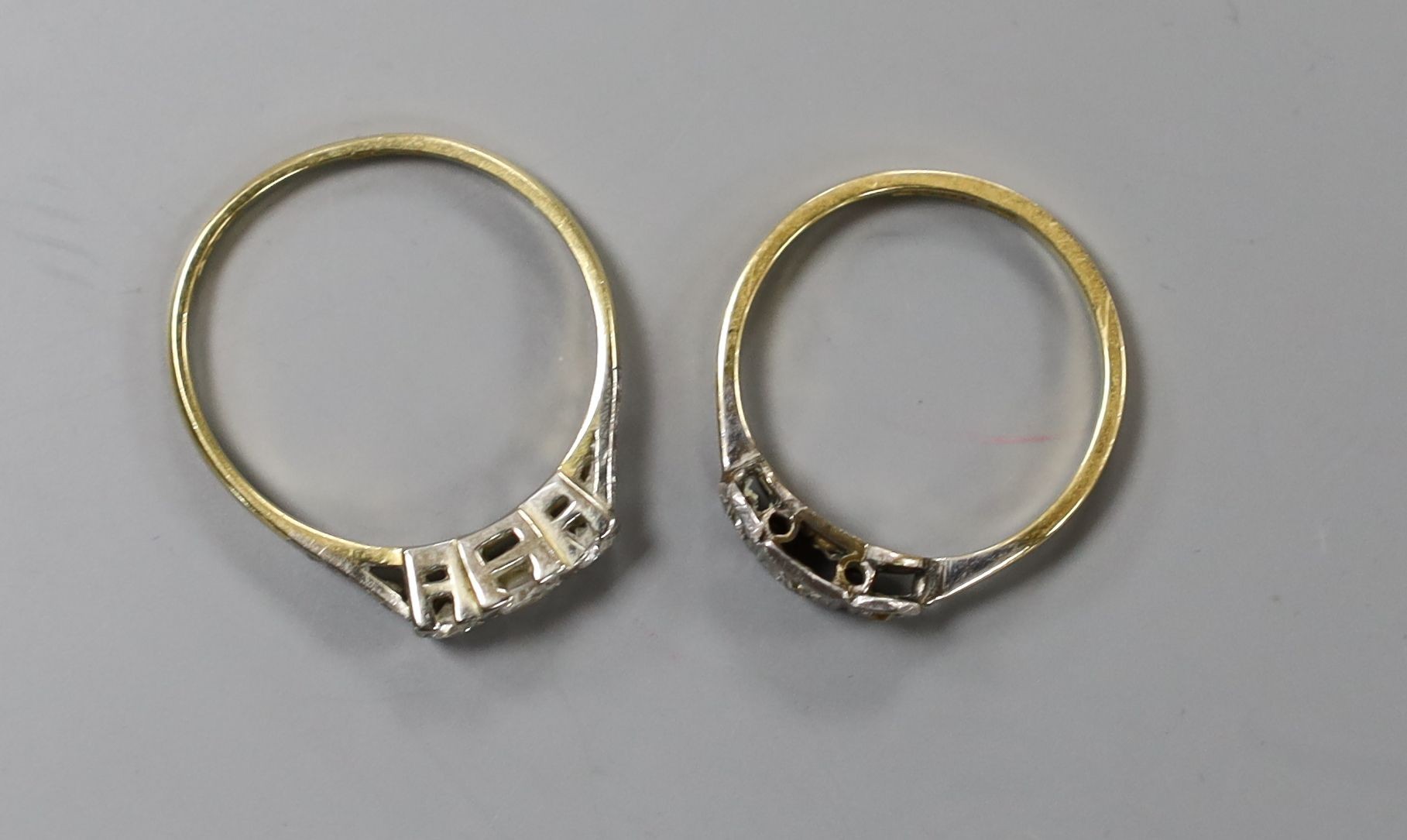 Two early 20th century yellow metal (one stamped 18ct & plat) and three stone diamond rings, one with diamond set shoulders, sizes N & Q, gross weight 4.1 grams.